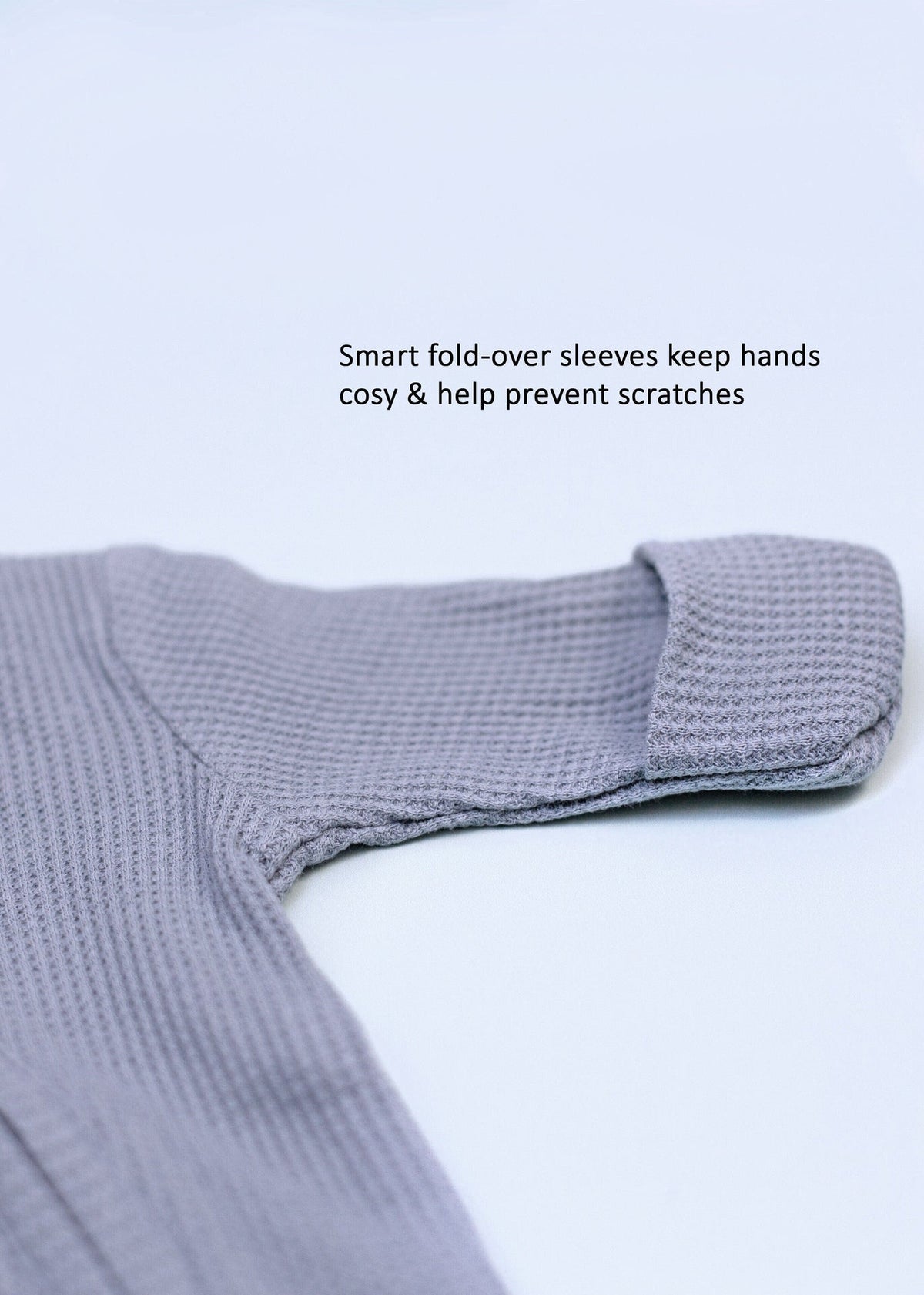 Blue waffle zip sleepsuit with integrated mitts on a premature baby