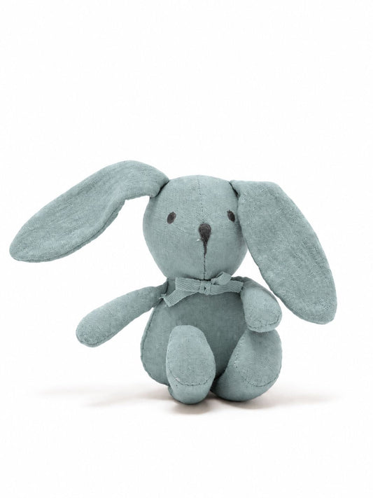 A light blue-gray plush bunny toy with long floppy ears, small dark embroidered eyes and nose, and a matching fabric bow around its neck, photographed on a clean white background.