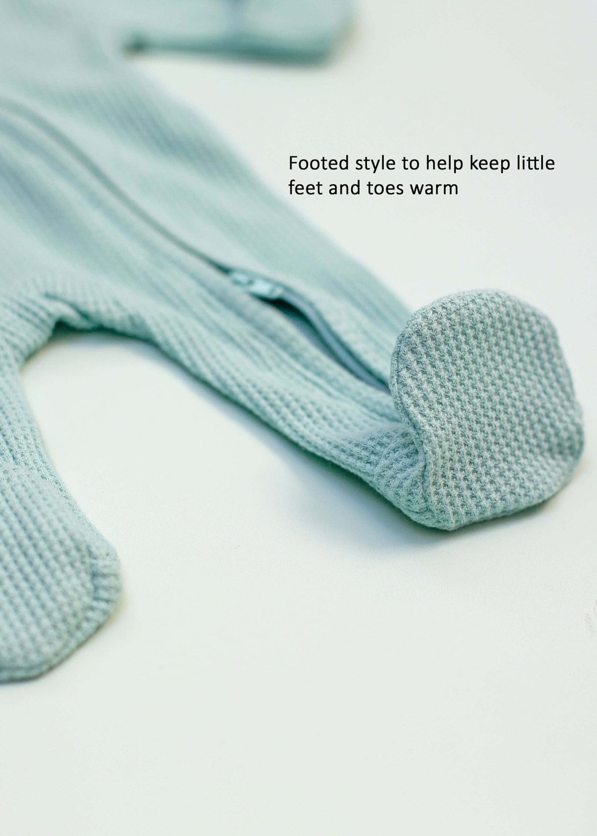Mint green waffle zip sleepsuit with integrated mitts on a premature baby
